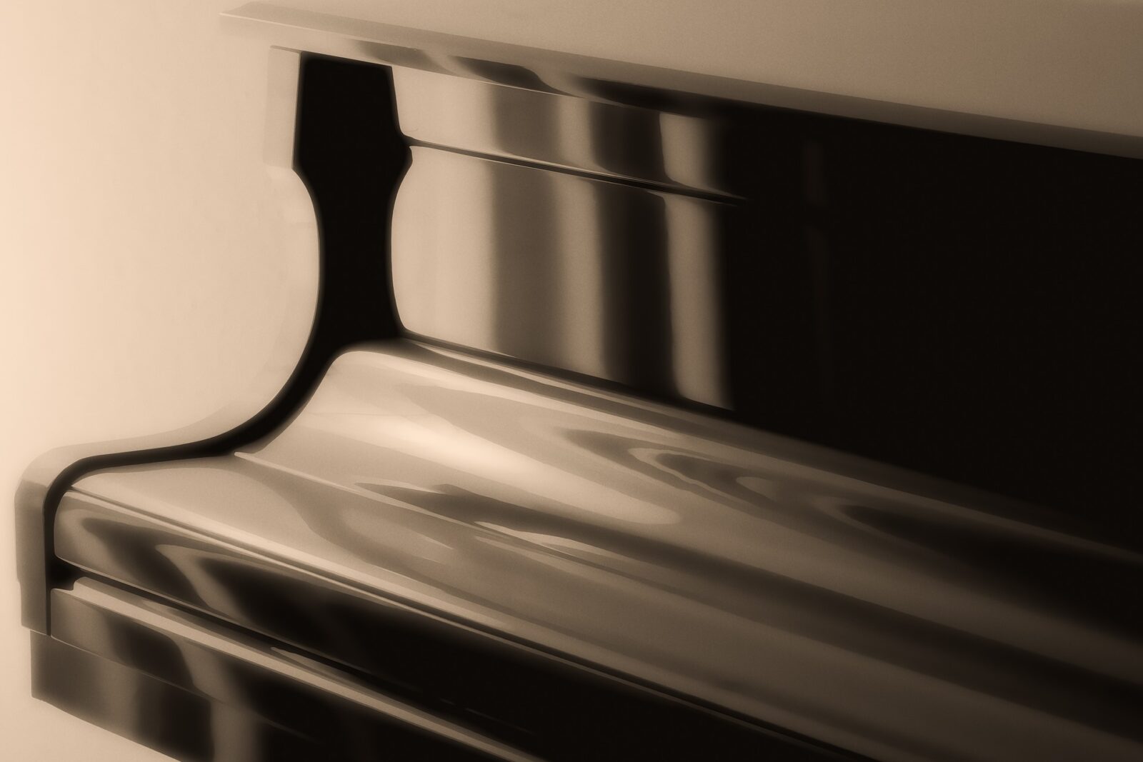 Soft focus black and white photograph of a piano with the keyboard cover closed.